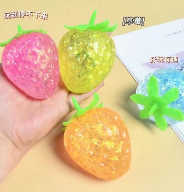 aurora glitter strawberry slow-rise squishy assortment in translucent pink yellow-green and orange colorways