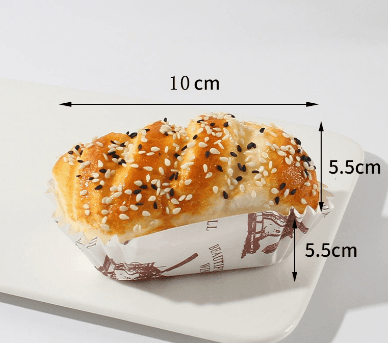braided sesame bread PU squishy toy shown in paper baking tray with 10 by 5.5 by 5.5 cm reference