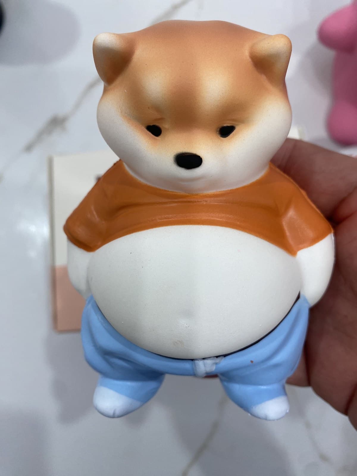 Close-up of the same custom PU animal character showing its face, orange shirt, round belly and blue trousers