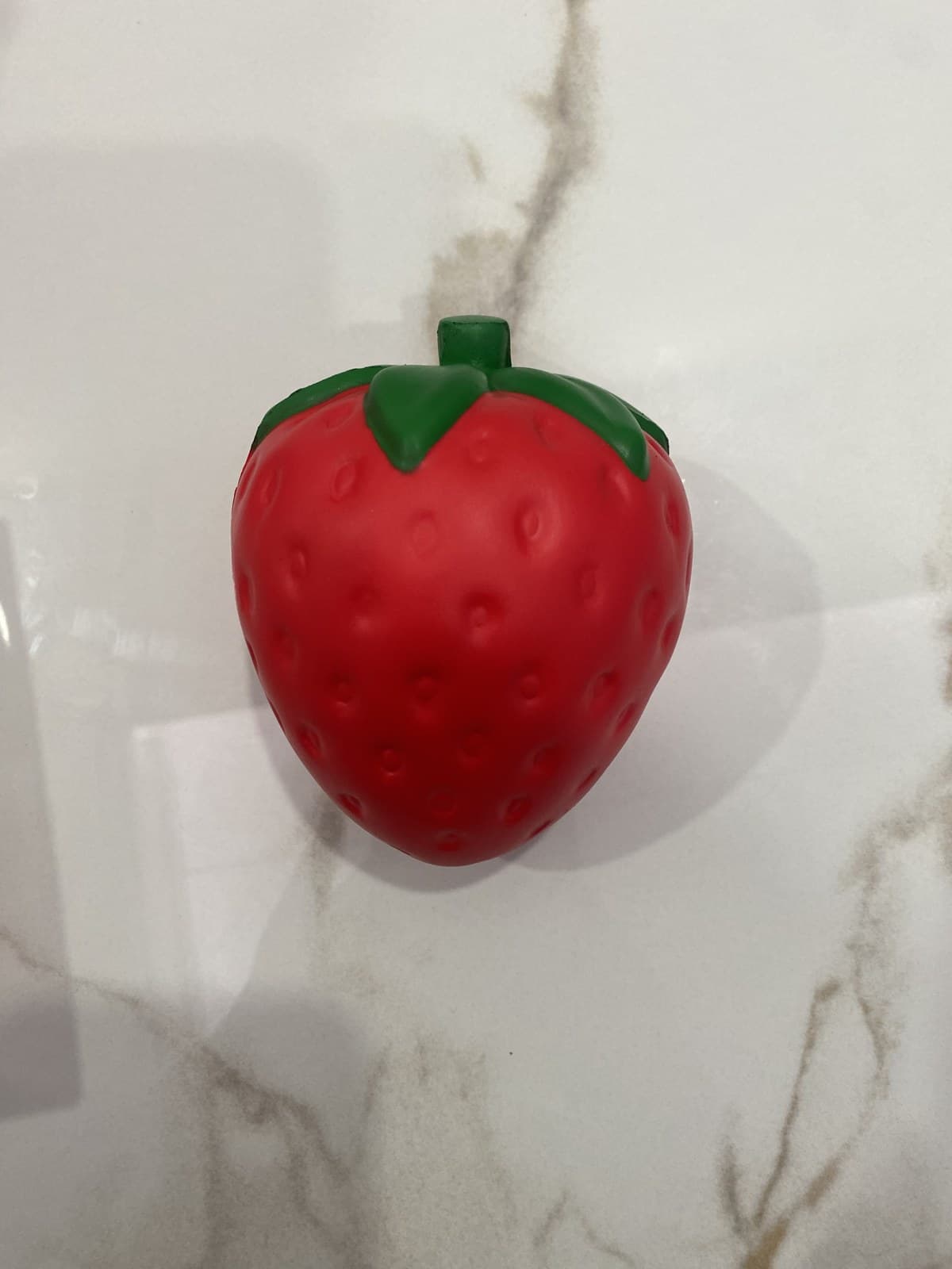 Custom red PU strawberry squishy with molded seed details and green leaves